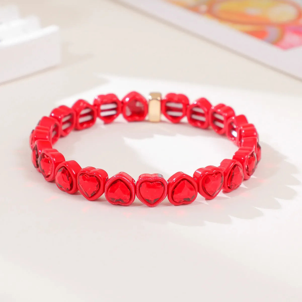 Colourful enamel heart shape on a silver-toned alloy stretch bracelet.