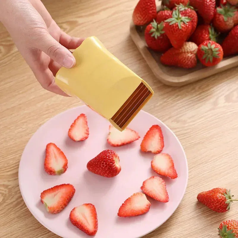 Green stainless steel cup-shaped kitchen slicer for cutting fruits and eggs on a countertop.