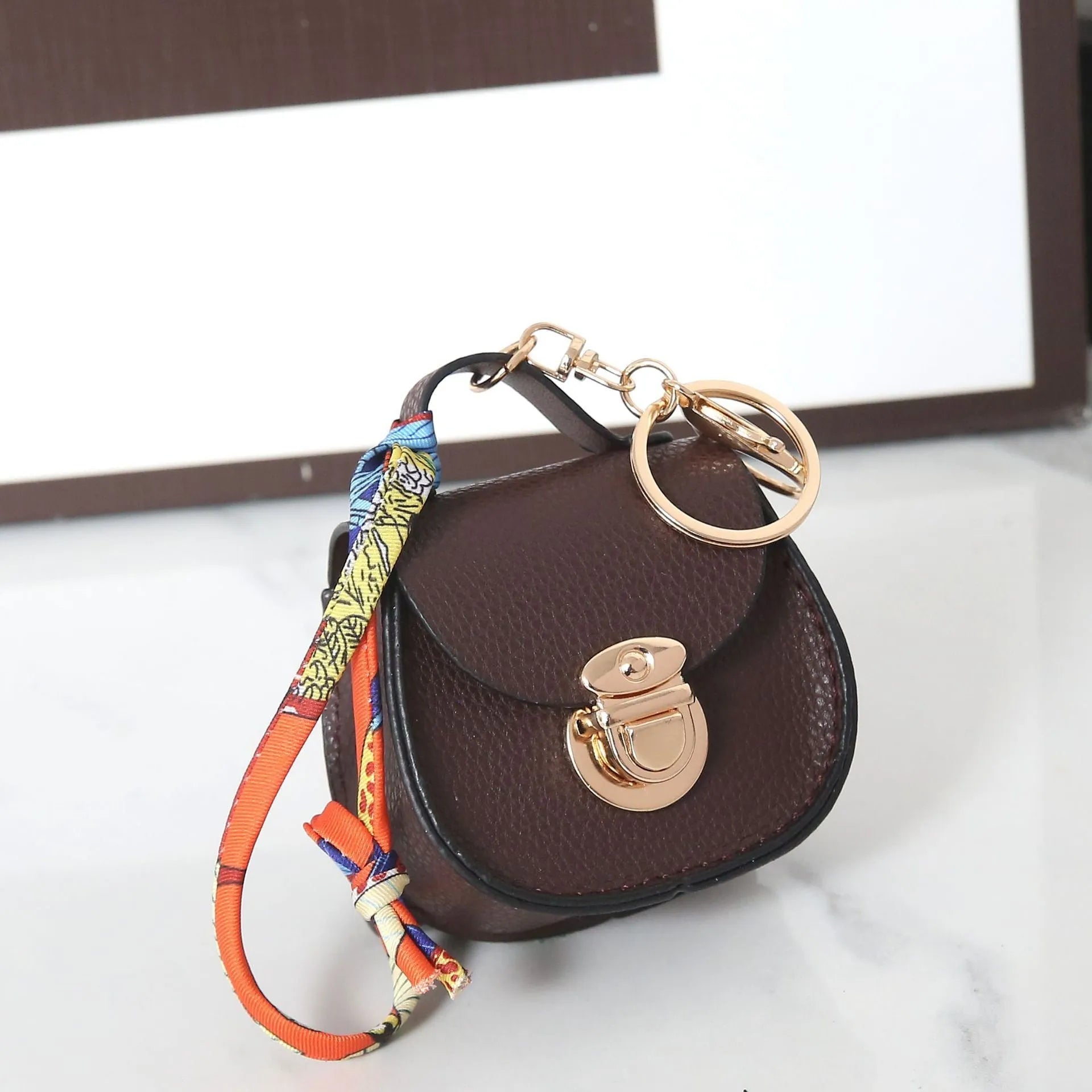 Solid colour PVC coin purse keychain shown in saddle bag black, orange, brown, red, grey, and pink.