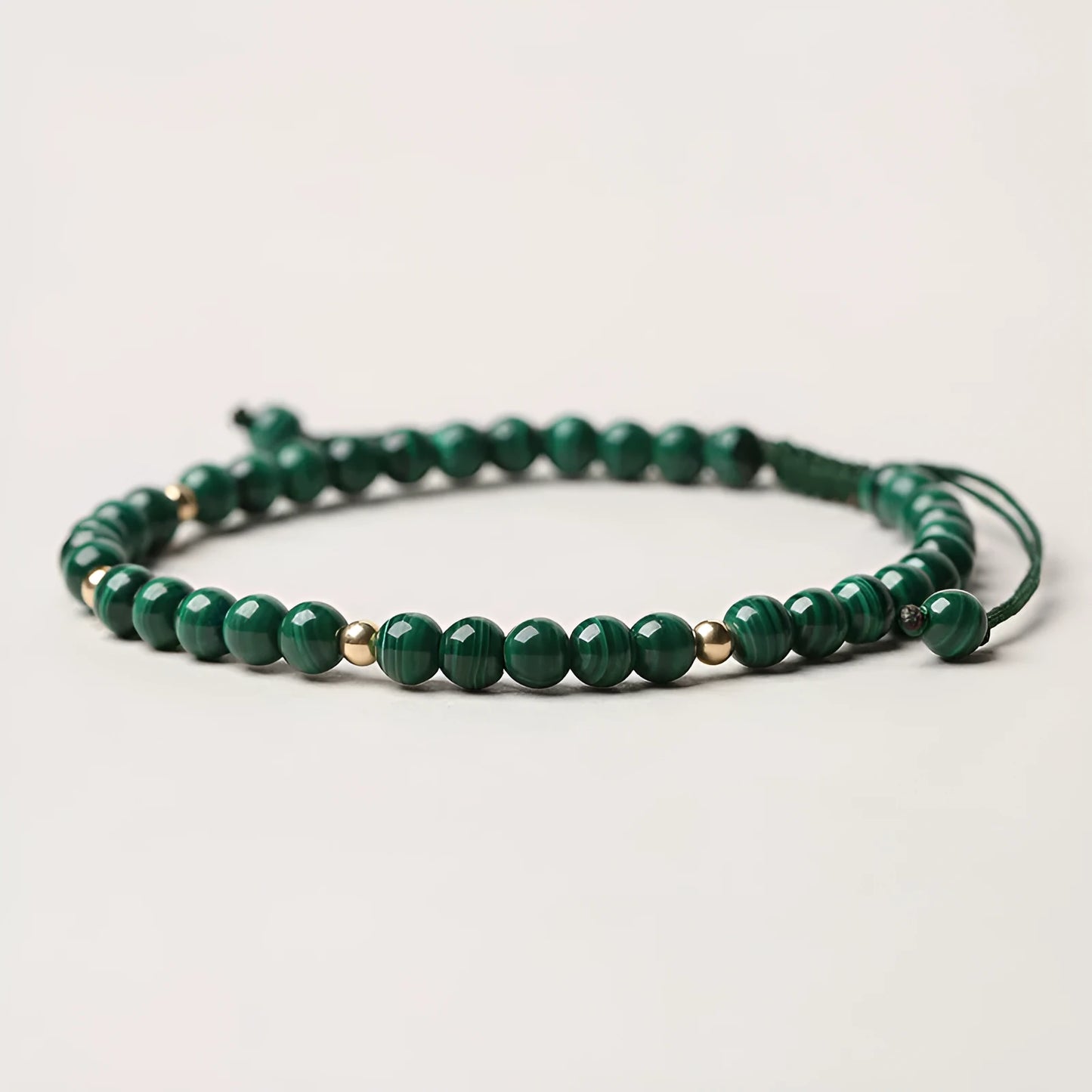 Handwoven green malachite crystal bracelet for women with golden ball accents.