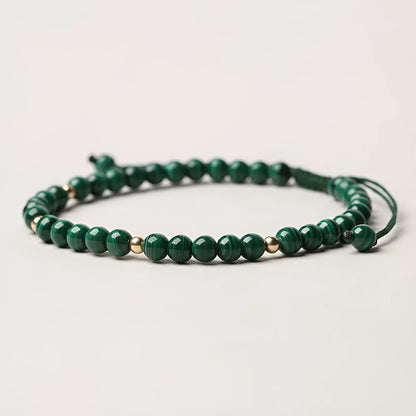 Handwoven green malachite crystal bracelet for women with golden ball accents.