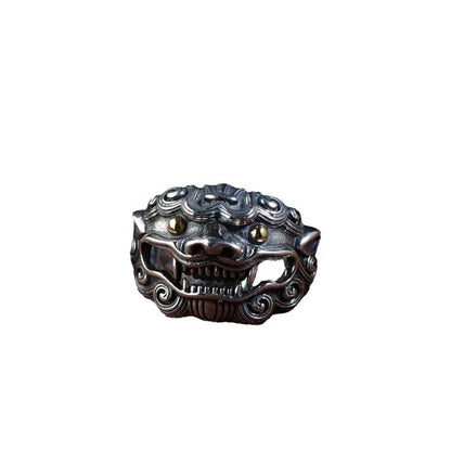 Domineering open ring with engraved animal pattern on wide sterling silver band, shown on a finger.
