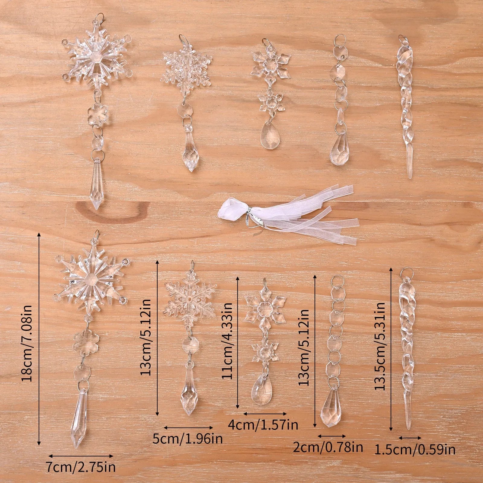 Set of ten clear acrylic icicle-shaped Christmas tree ornaments with white ribbons on green pine branches.