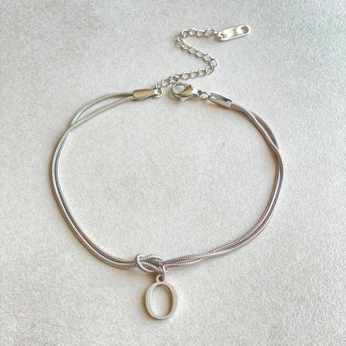 Elegant letter charm bracelets for women in gold and silver tones, featuring a delicate snake chain design and personalised letter charms.