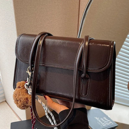 Brown women's square shoulder bag with double straps and pendant accessory