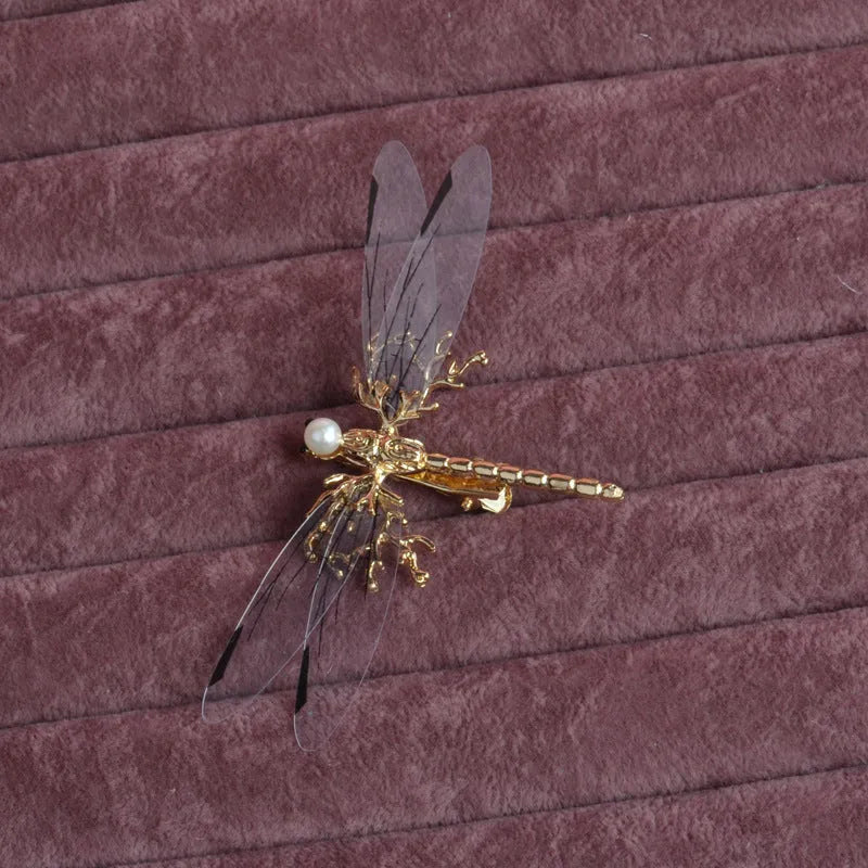 Golden dragonfly-shaped alloy hair clip with electroplated finish and a clip fastening.