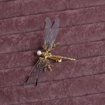 Golden dragonfly-shaped alloy hair clip with electroplated finish and a clip fastening.