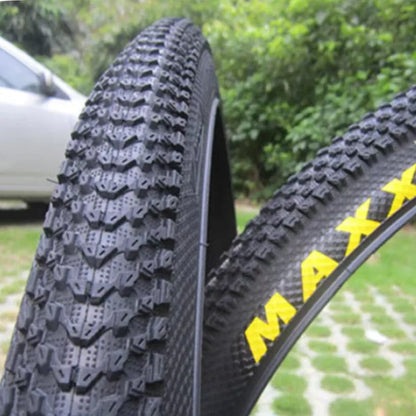 Mountain bike tyre with black tread and sidewall, showing size options like 26x1.95 and 29x2.1 inches for off-road cycling.