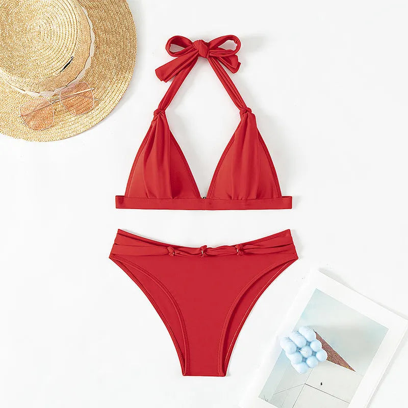 Red women's lace-up halterneck bikini top and shorts set on a mannequin