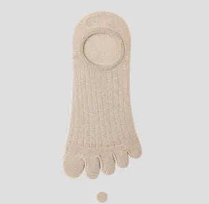 Pair of solid colour modal five-finger invisible socks on a wooden surface, showing toe separation and low-cut design.