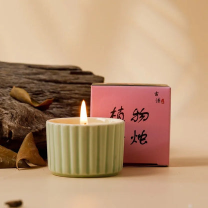Soy wax aromatherapy candle inside a handmade ceramic cup, shown in a mint green colour.
