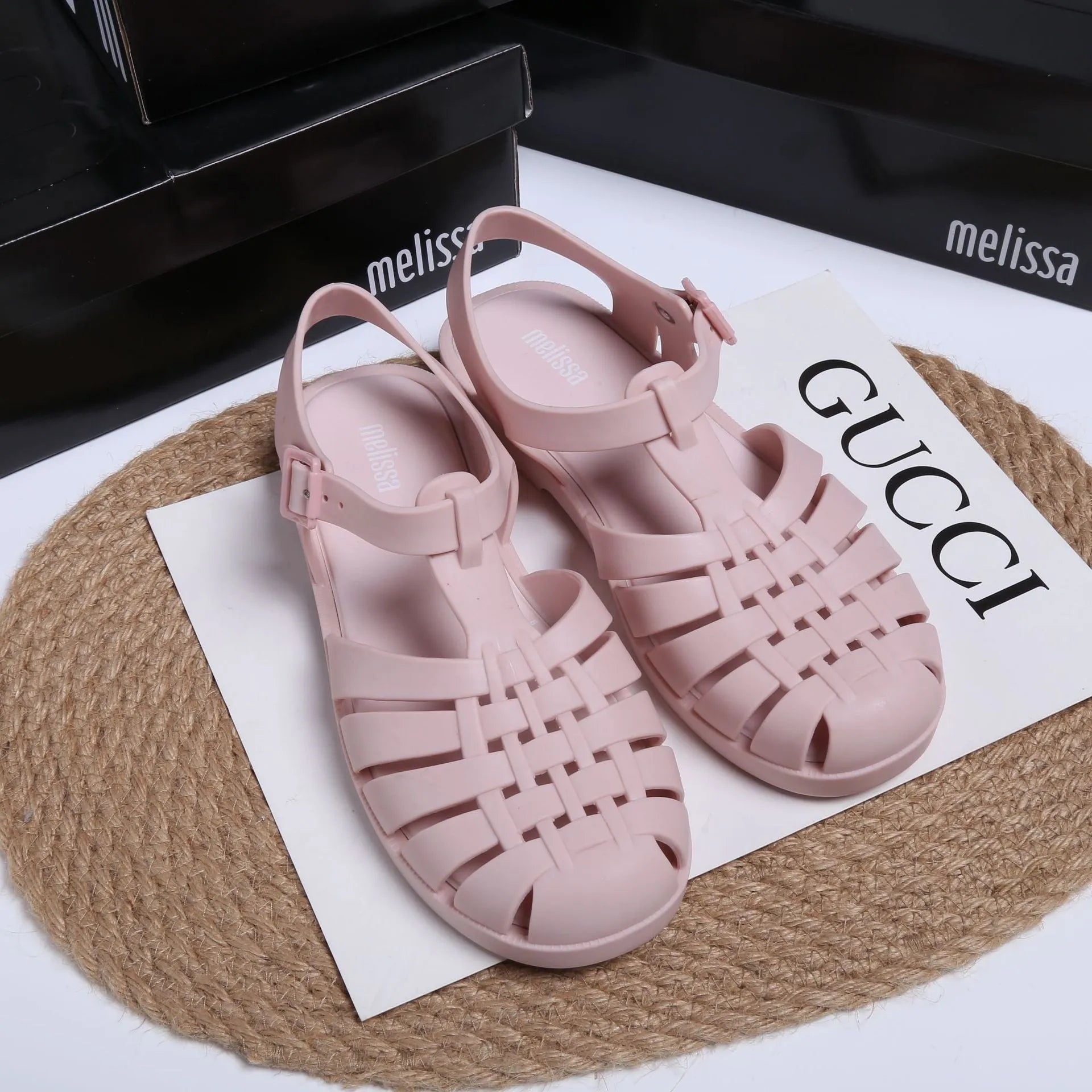 Matte black Roman sandals with vintage weave pattern, buckle fastening, and low-top PVC construction