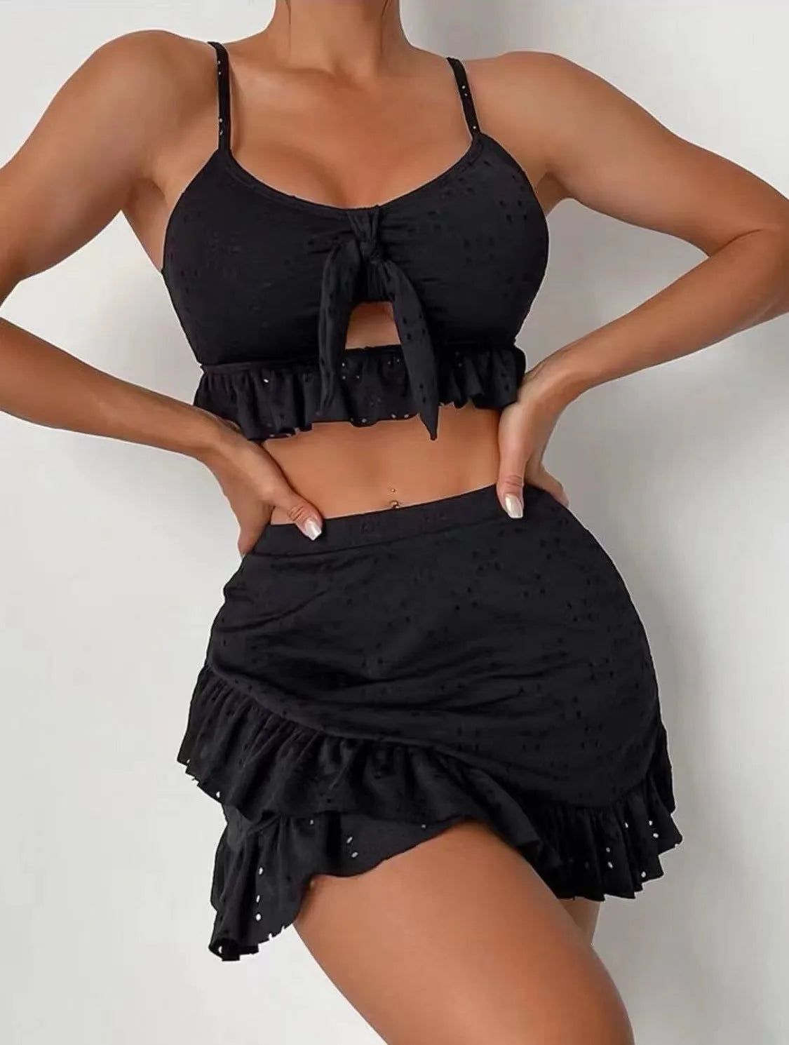 Women's solid colour three-piece bikini swimsuit with a split hip skirt.