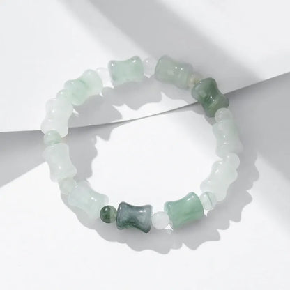 Simple Korean-style bracelet with natural chalcedony and coconut shell beads on an elastic string, showing the diamond-shaped safety lock.