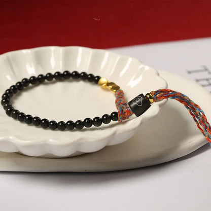 Close-up of a hand-woven obsidian bracelet with a 4mm wide strap on a wrist.