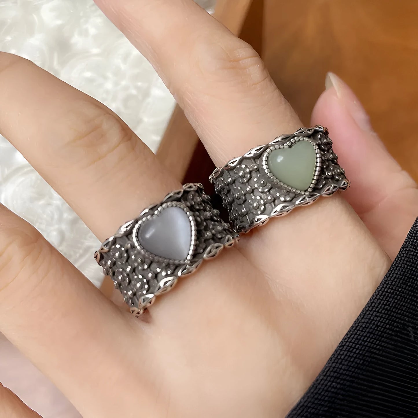 Retro style wide silver heart shape ring with adjustable band on a wooden surface