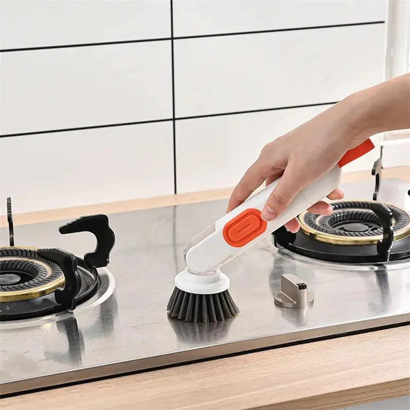 White and red long-handle kitchen brush with soap dispenser button and two interchangeable scrub heads on a hook.