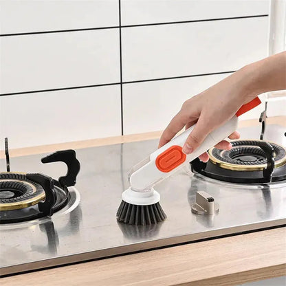 White and red long-handle kitchen brush with soap dispenser button and two interchangeable scrub heads on a hook.