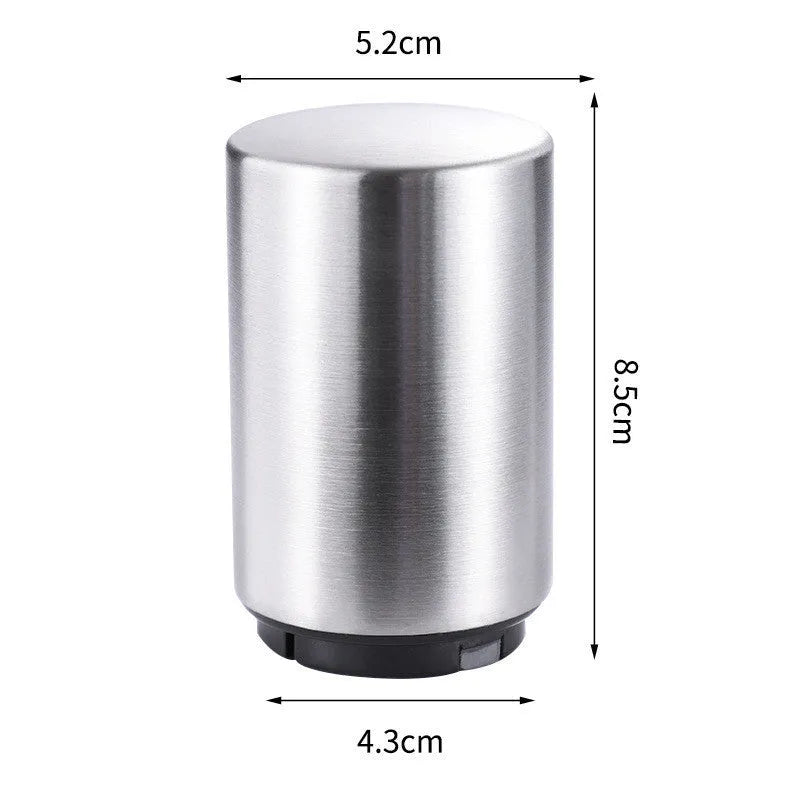 Stainless steel automatic bottle opener measuring 8.4 cm by 5.3 cm on a kitchen counter
