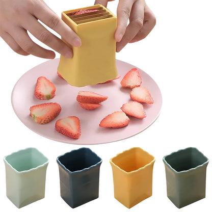 Green stainless steel cup-shaped kitchen slicer for cutting fruits and eggs on a countertop.