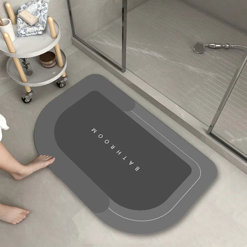 Oval diatomite bathroom floor mat in blue with natural rubber non-slip backing on tiled floor.