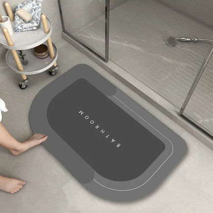 Oval diatomite bathroom floor mat in blue with natural rubber non-slip backing on tiled floor.