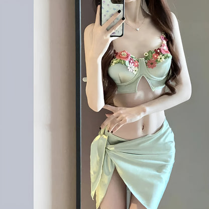 Green women's bikini three-piece set with triangle top, pants, and skirt