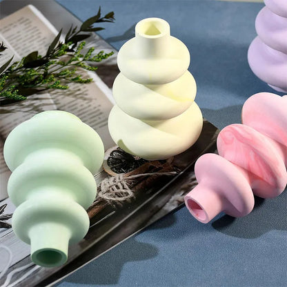 Silicone baking mould in shape of three-layer irregular circle vase on white background