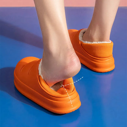 Pair of yellow waterproof EVA slippers with plush lining and a textured non-slip sole on a wooden floor.