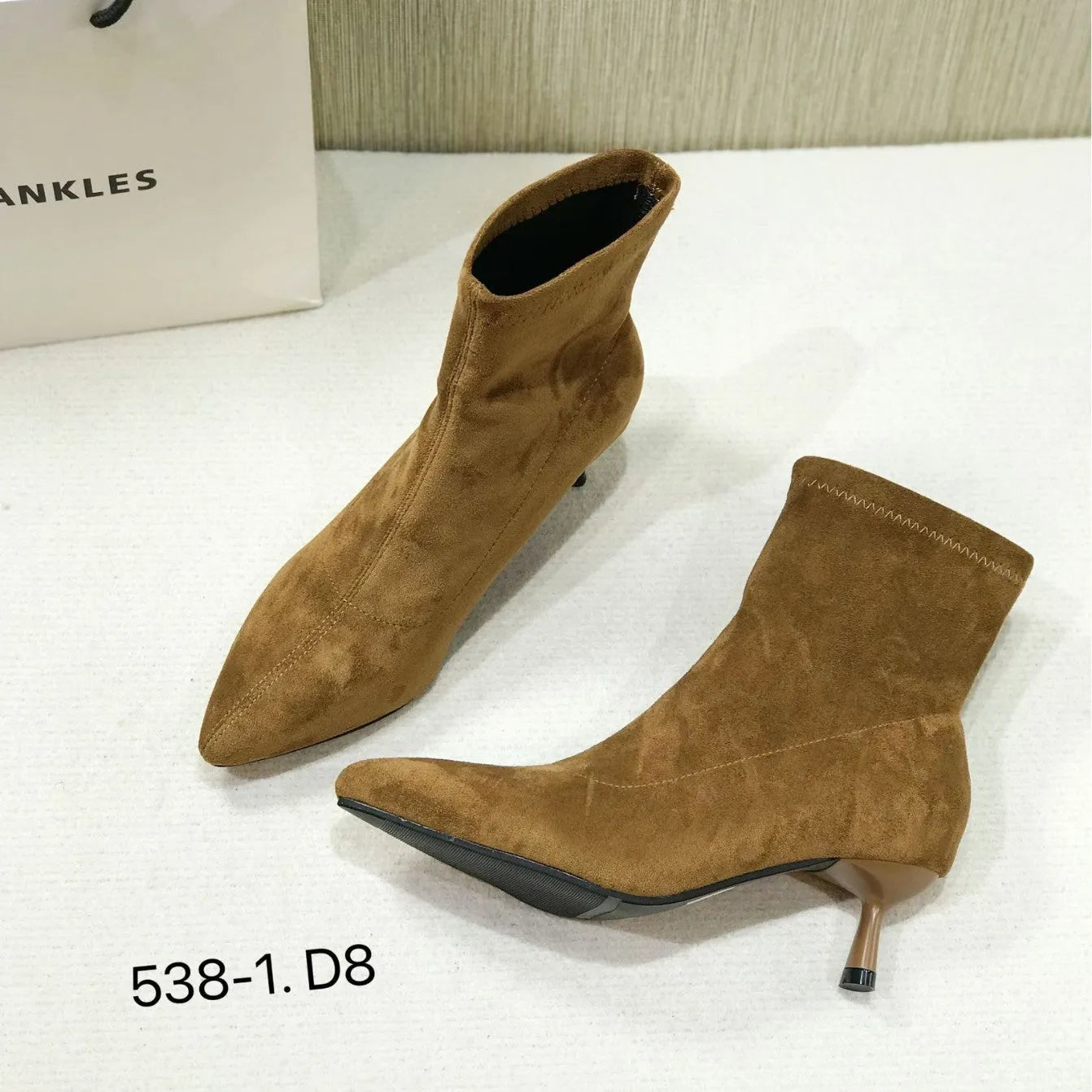 Women's black pointed toe ankle boots with a stiletto heel on a neutral background
