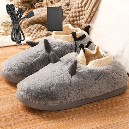 USB heating slippers in black plugged into a laptop, showing the cable and soft velvet upper.