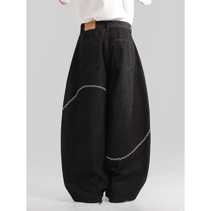Men's black straight-leg denim trousers on a hanger, showing mid waist and zip fly detail.