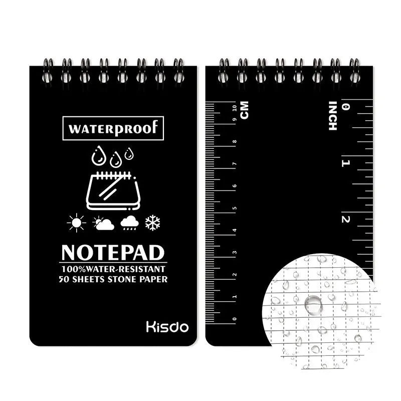 Spiral-bound waterproof notepad in camouflage colour, open on a wooden surface with a pen.