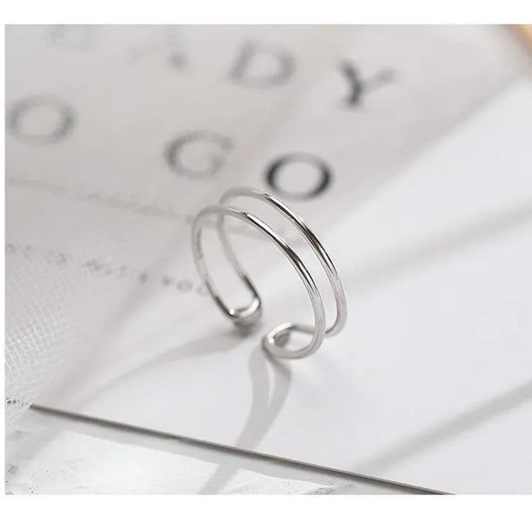 Silver plated geometric cross ring for women with adjustable opening on a white background