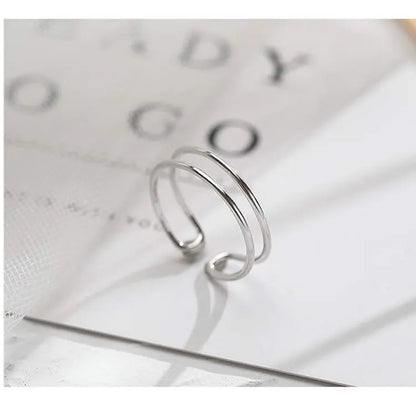 Silver plated geometric cross ring for women with adjustable opening on a white background