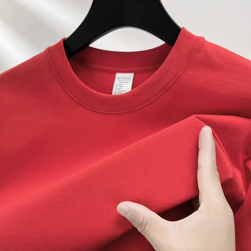 Men's thin cotton drop shoulder t-shirt on a hanger, shown in a light colour.