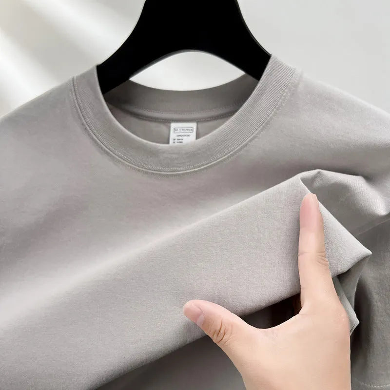Men's thin cotton drop shoulder t-shirt on a hanger, shown in a light colour.