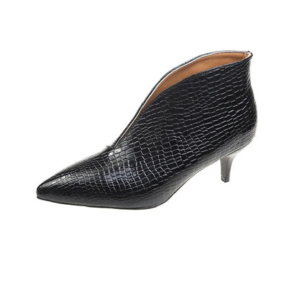 Women's black V cut Martin boots with a pointed embossed toe and a chunky heel.