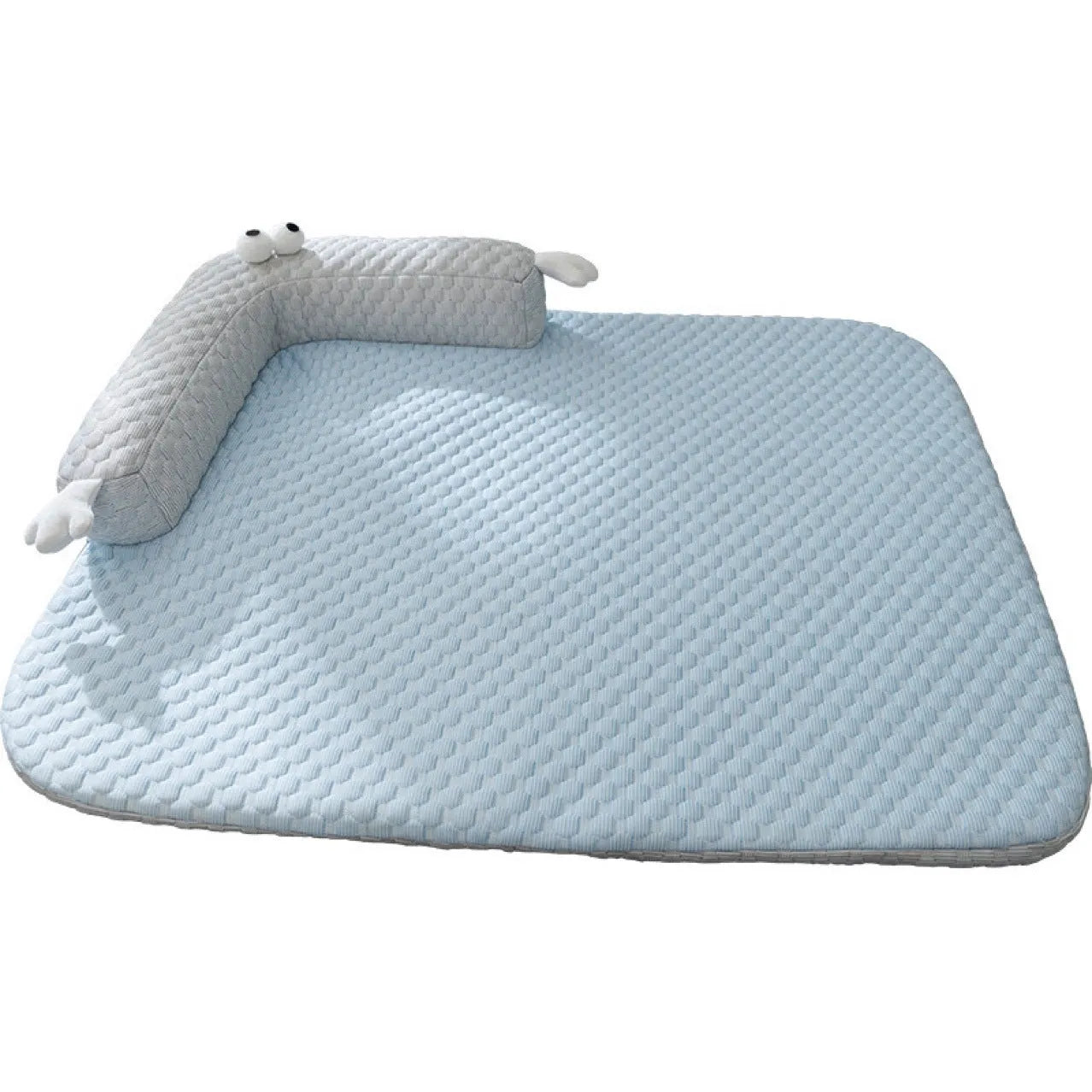 Blue pet bed cushion with big-eyed monster design, shown on a wooden floor.