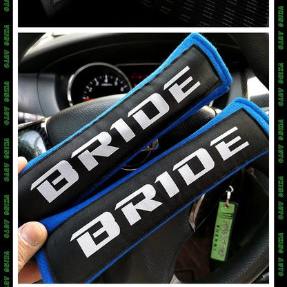 Car seat belt shoulder pad protectors in black, blue, and red colours with embroidered woven detailing
