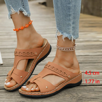 Beige Roman style slippers with a fish mouth toe, slope heel, and rubber sole.
