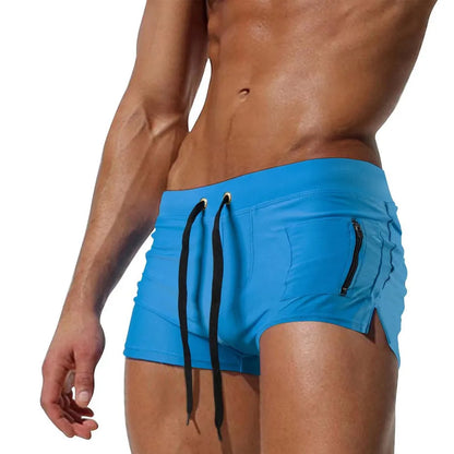 Men's black high-waisted swimming trunks with a lace-up front closure, shown on a model.