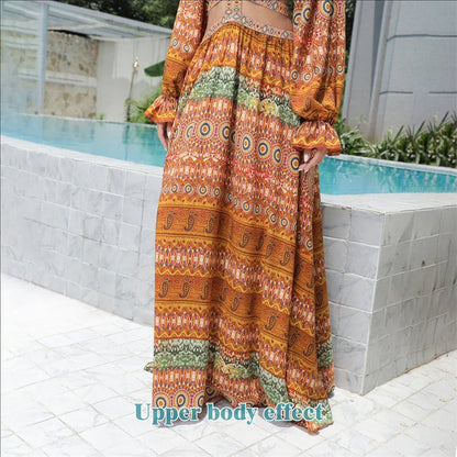 Elegant floral print dress with long sleeves and empire waistline in vibrant orange color