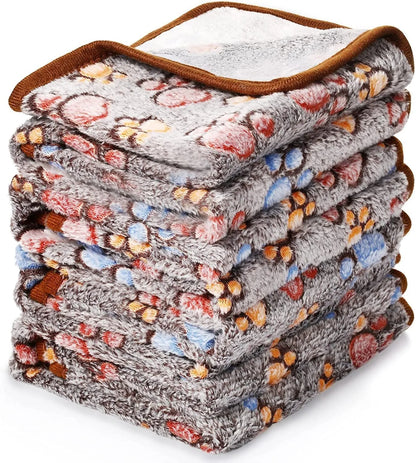 Coral fleece dog blanket with paw print pattern, shown in beige colour, laid flat to show size and soft texture.