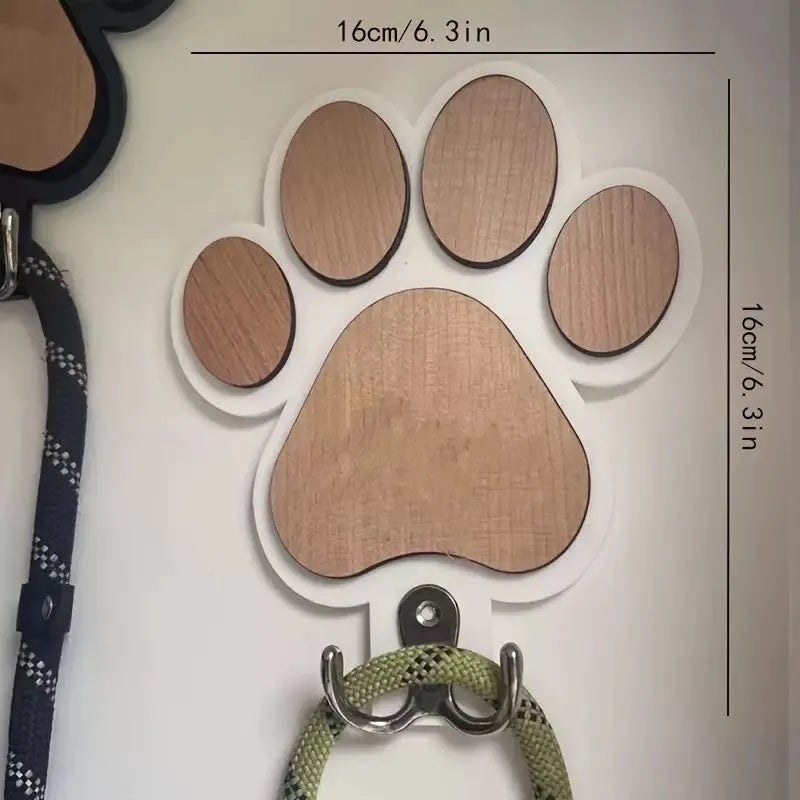 Black wooden wall hook shaped like a paw print foot on a white wall