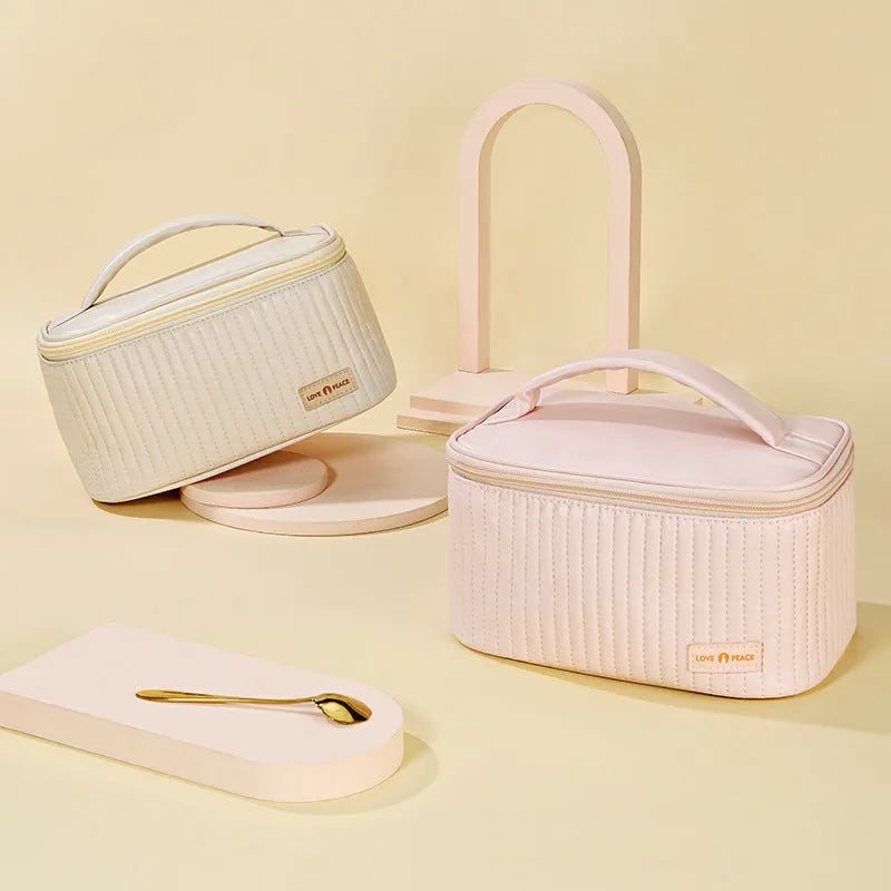 Open-top pastel pink PU leather makeup bag with a flat base, showing interior space.