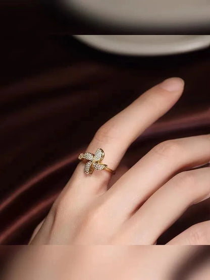 Gold and silver kinetic rings showing a geometric copper band with a central spinning windmill detail.