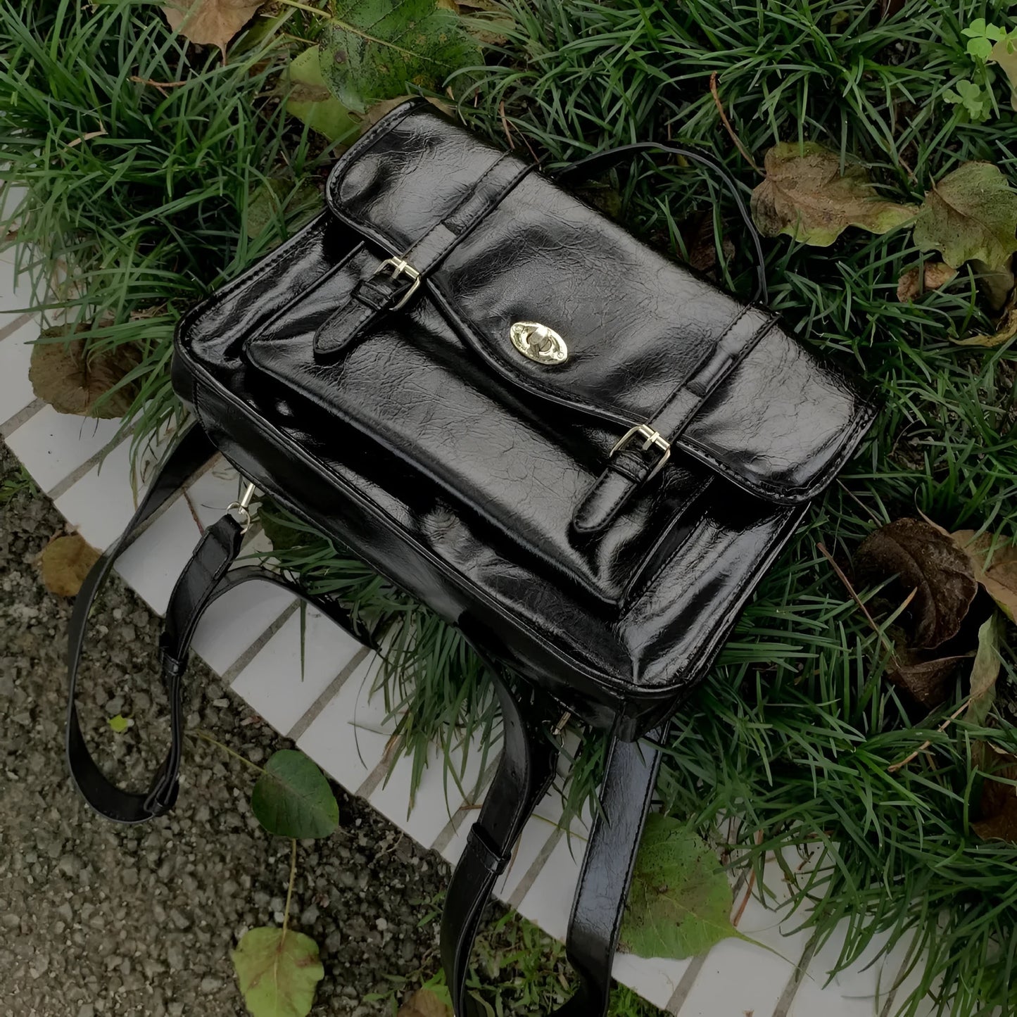 Black college style messenger bag made of oil wax PU leather, shown with a single shoulder strap.