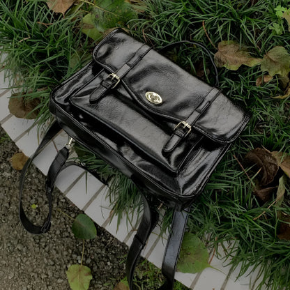 Black college style messenger bag made of oil wax PU leather, shown with a single shoulder strap.