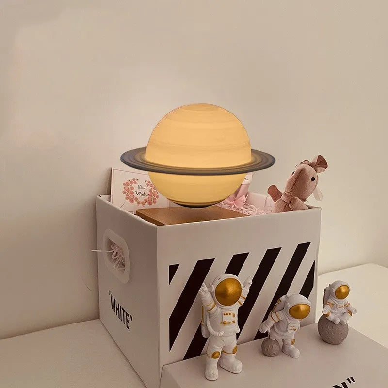 Maglev floating moon planet atmosphere night light with three astronaut figurines on a desk.